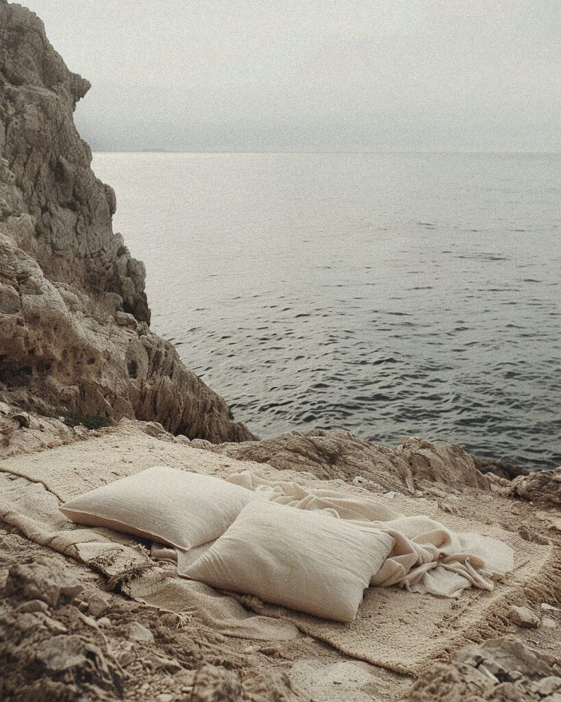 editorial, earthy coastal landscape, soft shading, white, picnic rug, minimalist purity, in the style of surreal still life compositions, muted beige, cinematic, ocean, rocky landscape --ar 4:5 --style raw --stylize 150 Job ID: 666e86fc-70bf-4aaa-9d64-bf0ed494bf85